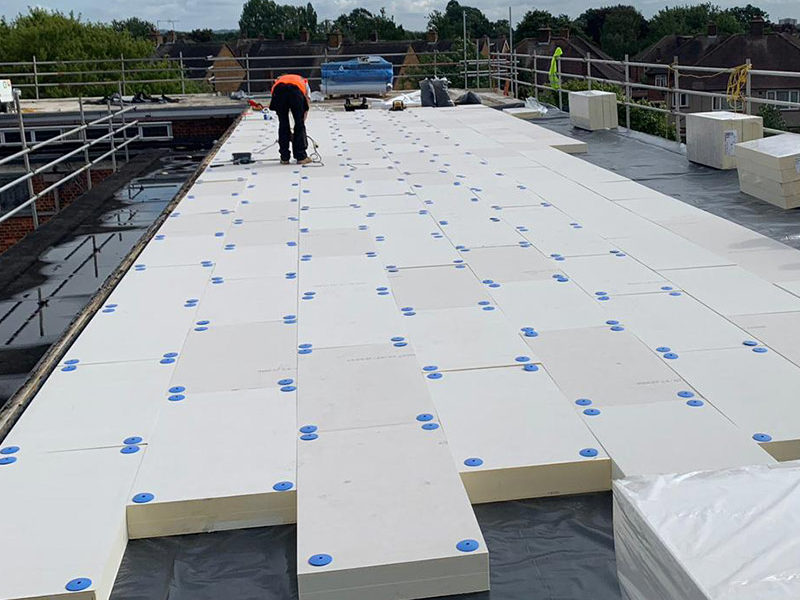 worker replacing commercial flat roofing in london